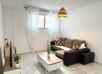 a living room with a couch and a coffee table at Playa Fuentebravia apartament in El Puerto de Santa María