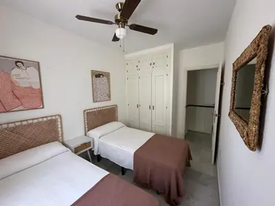 a bedroom with two beds and a ceiling fan at Chalet adosado en Novo Sancti Petri in Cádiz