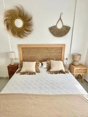a bedroom with a large bed with two pillows at Chalet adosado en Novo Sancti Petri in Cádiz