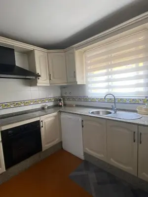 a kitchen with white cabinets and a sink and a window at Apartamento Capillera 9 in El Puerto de Santa María