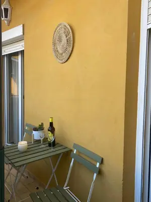 a table with two chairs and a fan on a wall at Apartamento Capillera 9 in El Puerto de Santa María