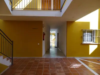 an empty hallway of a building with yellow walls at Apartamento Capillera 9 in El Puerto de Santa María
