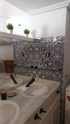 a bathroom with two sinks and a tile wall at Marina Sur in San Fernando