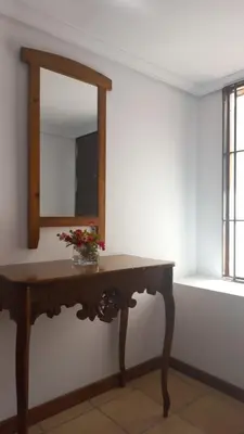 a wooden table with a mirror on a wall at Marina Sur in San Fernando