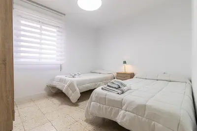 two beds in a white room with a window at Sherry Sunset in Jerez de la Frontera