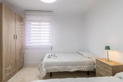 a white bedroom with a bed and a window at Sherry Sunset in Jerez de la Frontera
