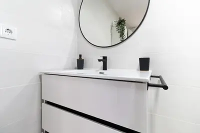 a white bathroom with a mirror and a sink at Rinconcito Sanlucar de Barrameda in Sanlúcar de Barrameda