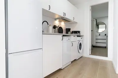 a white kitchen with a washer and dryer at Rinconcito Sanlucar de Barrameda in Sanlúcar de Barrameda
