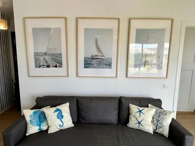 a living room with a couch and four pictures on the wall at GATU Náutico 
