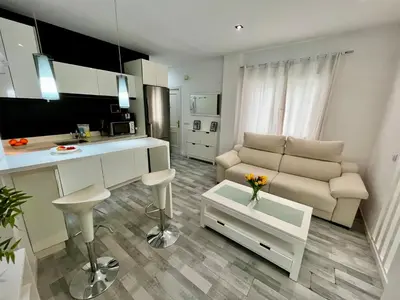 a kitchen and living room with a couch and a table at GATU Alquiladores 