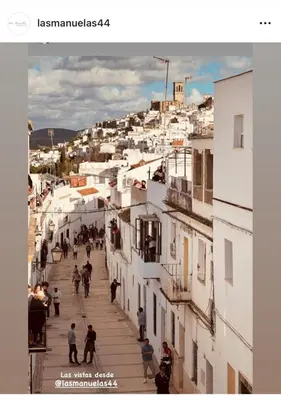 a group of people walking down a street with buildings at Las Manuelas in Arcos de la Frontera