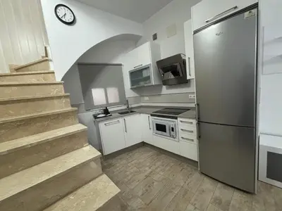 a kitchen with a staircase and a stainless steel refrigerator at Las Manuelas in Arcos de la Frontera