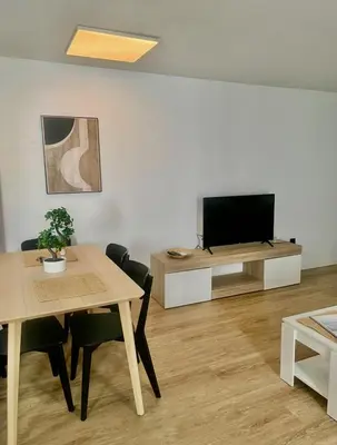 a living room with a table and a flat screen tv at Alma gaditana en la caleta in Cádiz