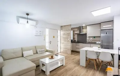 a living room with a couch and a table and a kitchen at Alma gaditana en la caleta in Cádiz