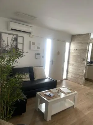 a living room with a black couch and a coffee table at Alma gaditana en la caleta in Cádiz