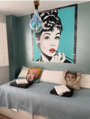 a bed with a large painting on the wall at Alma gaditana en la caleta in Cádiz