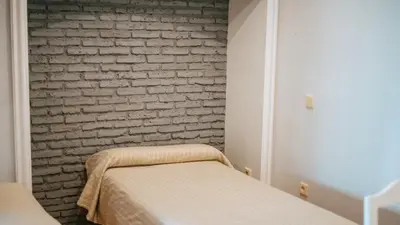 a bedroom with a brick wall and two beds at Bungalows Bahia Sur in San Fernando