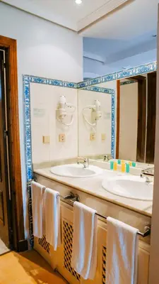 a bathroom with two sinks and a mirror and towels at Bungalows Bahia Sur in San Fernando