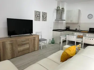 a living room with a white couch and a television at Austria 05 in Lebrija