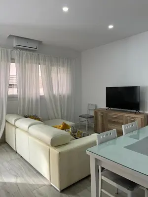 a living room with a white couch and a table at Austria 05 in Lebrija