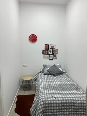 a bedroom with a bed and a clock on the wall at Austria 05 in Lebrija