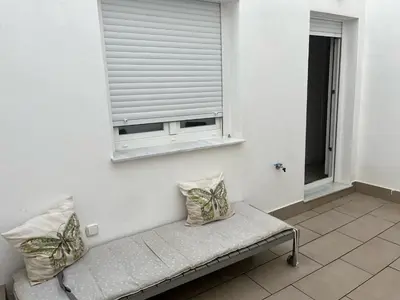 a bench with two pillows sitting under a window at Austria 05 in Lebrija