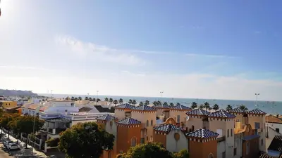 a group of buildings with the ocean in the background at Ático Mar in Sanlúcar de Barrameda