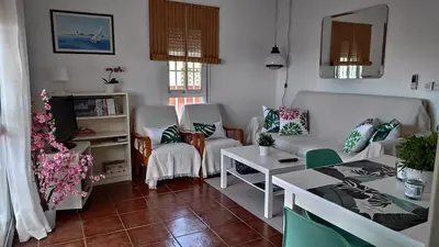 a living room with a couch and chairs and a table at Ático Mar in Sanlúcar de Barrameda