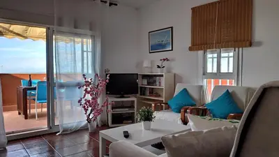 a living room with a couch and a tv at Ático Mar in Sanlúcar de Barrameda