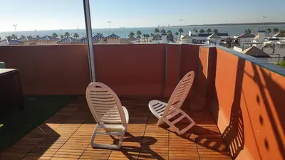 two chairs on a balcony with a view of the ocean at Ático Mar in Sanlúcar de Barrameda