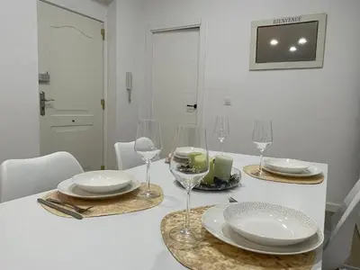 a white table with glasses and plates on it at Jardines de Santa María - Parking gratis in Jerez de la Frontera