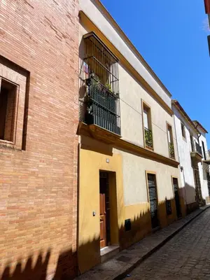 a brick building with a balcony with a dog in it at Jardines de Santa María - Parking gratis in Jerez de la Frontera
