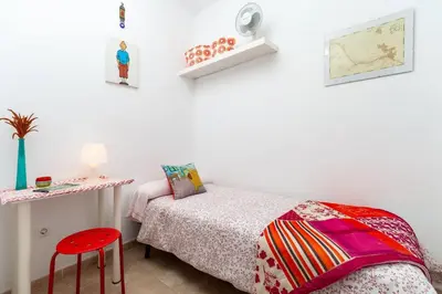 a bedroom with a bed and a red stool at Alojamientos Cadiz Sol in Cádiz