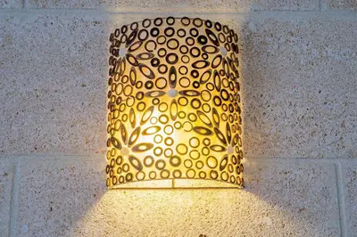 a lamp with a gold shade on a wall at Alojamientos Cadiz Sol in Cádiz