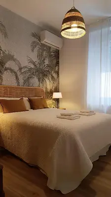 a bedroom with a large white bed and a chandelier at Sherryflat Terraza San Francisco in Jerez de la Frontera