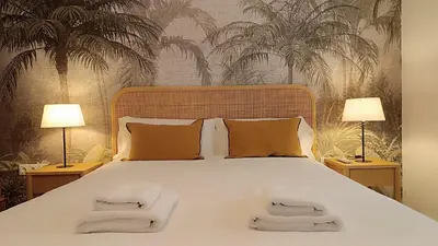 a bedroom with a large bed with two lamps at Sherryflat Terraza San Francisco in Jerez de la Frontera