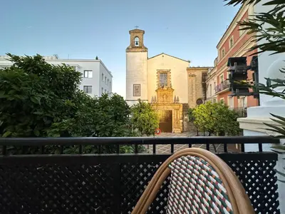 a bench sitting on a balcony in front of a building at Sherryflat Terraza San Francisco in Jerez de la Frontera