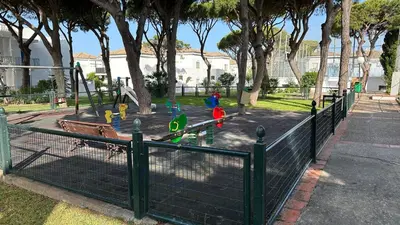 a park with a fence and a playground at Casa doble Almadraba in Novo Sancti Petri
