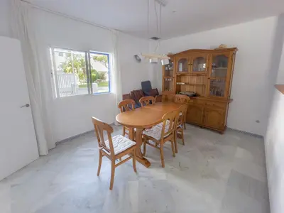 a dining room with a wooden table and chairs at Casa doble Almadraba in Novo Sancti Petri
