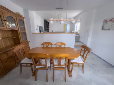 a dining room with a wooden table and four chairs at Casa doble Almadraba in Novo Sancti Petri