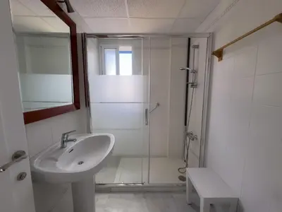 a white bathroom with a sink and a shower at Casa doble Almadraba in Novo Sancti Petri