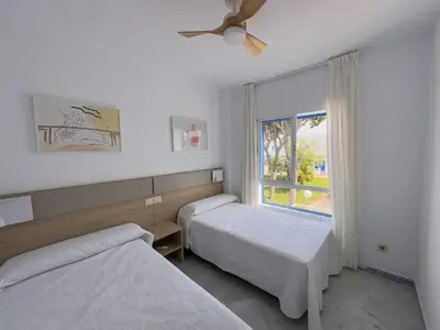 a hotel room with two beds and a window at Casa doble Almadraba in Novo Sancti Petri