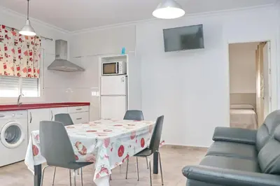 a kitchen and dining room with a table and chairs at Apartamento Canario IV in Conil de la Frontera