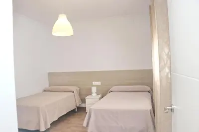 two beds in a room with white walls at Apartamento Canario IV in Conil de la Frontera
