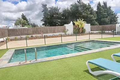 a swimming pool in a yard with a tennis court at Apartamento Canario IV in Conil de la Frontera