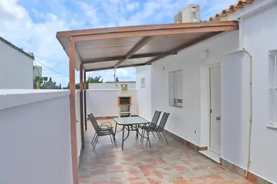 a patio with a table and chairs on a balcony at Apartamento Canario IV in Conil de la Frontera