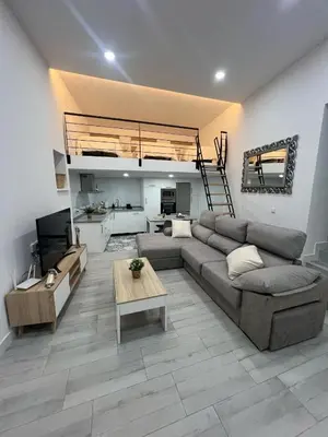 a living room with a couch and a table at Apartamento Bajo De Guía in Sanlúcar de Barrameda