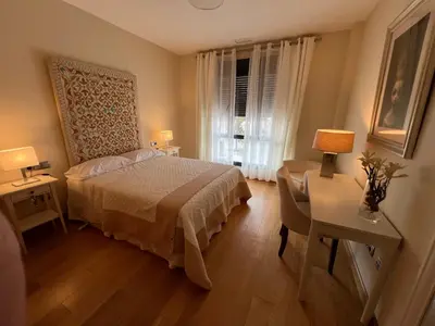 a bedroom with a bed and a desk and a window at Apartamento Jerez in Jerez de la Frontera