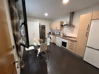 a kitchen with a glass table and white appliances at Apartamento Jerez in Jerez de la Frontera