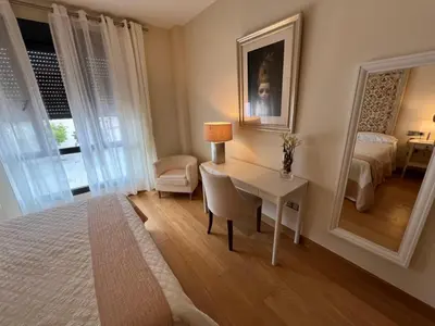 a bedroom with a desk and a bed and a mirror at Apartamento Jerez in Jerez de la Frontera